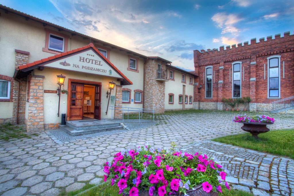 a hotel with flowers in front of a building at Hotel na Podzamczu in Tarnowskie Góry
