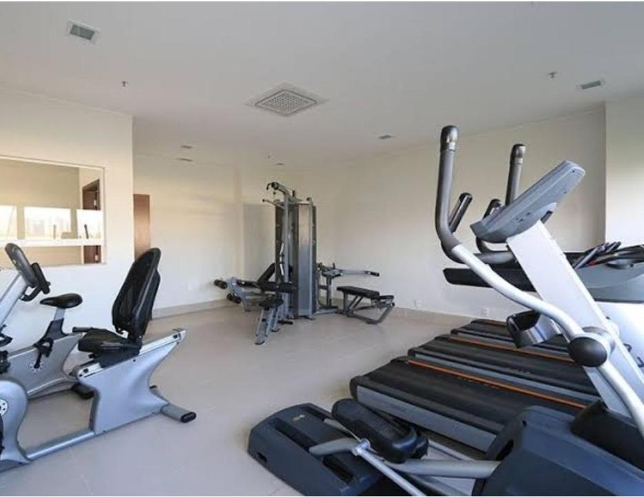 a gym with several treadmills and cardio machines at Flat Premiere in Rio de Janeiro