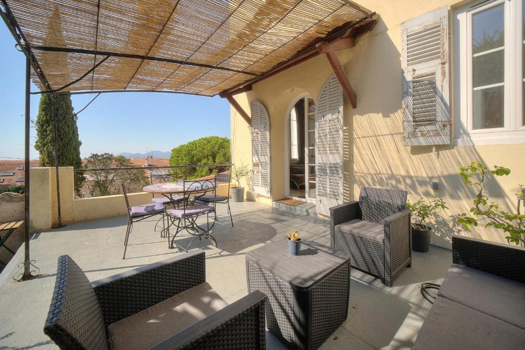 une terrasse avec une table, des chaises, une table et des chaises dans l'établissement IMMOGROOM - T3 - Garden - Quiet - Air conditioning, à Cannes