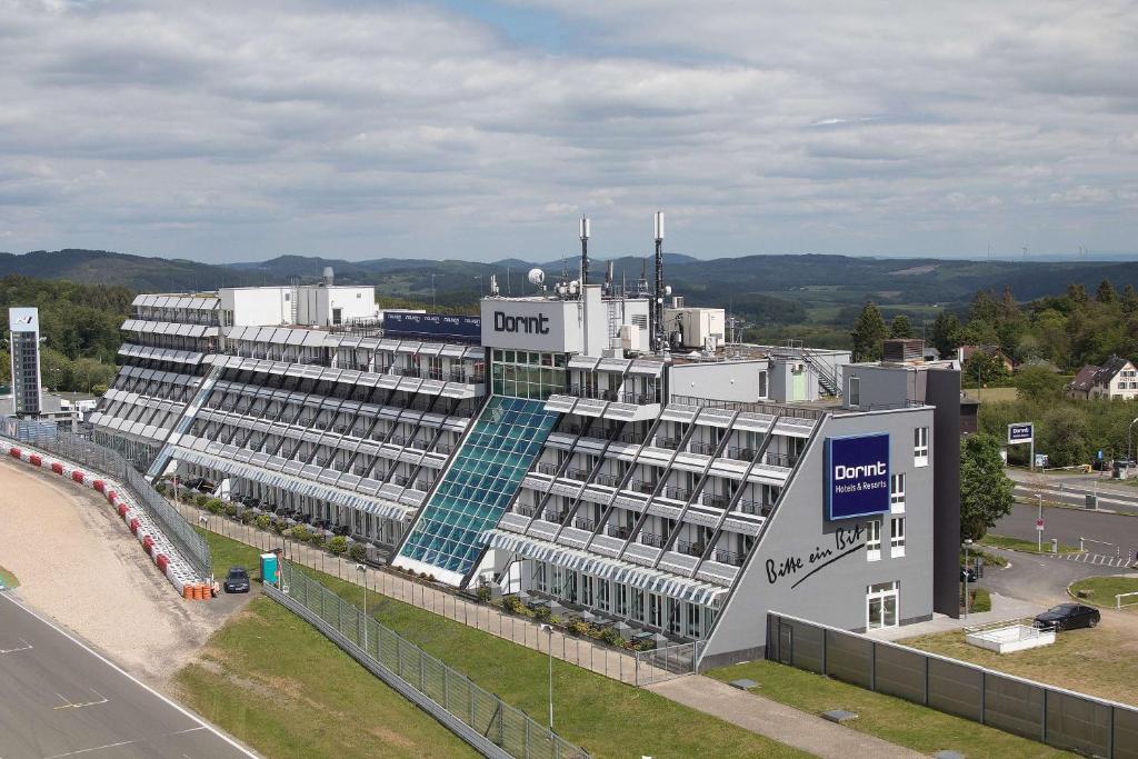 un grand bâtiment avec un panneau sur son côté dans l'établissement Dorint Am Nürburgring Hocheifel, à Nürburg