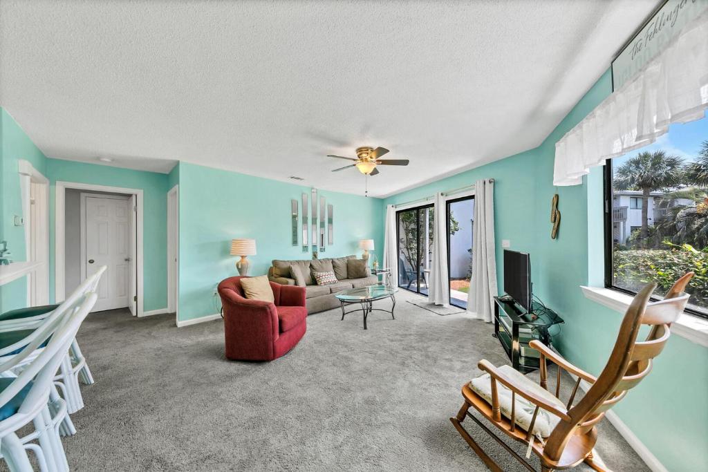 a living room with blue walls and a red couch at Crystal Village II 18A - 2Bedroom 2BA Condo near the Beach Sleeps 6! in Destin