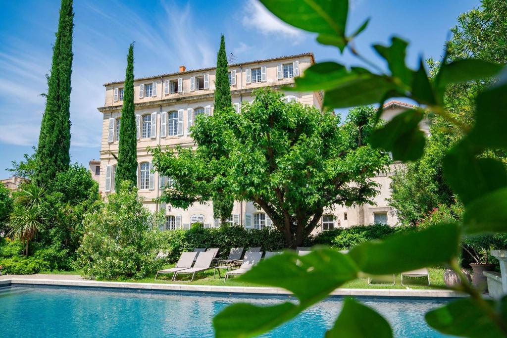 a large building with a swimming pool and trees at Château de Mazan, BW Premier Collection by Best Western in Mazan