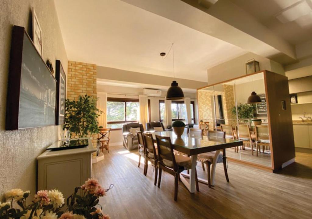 uma sala de jantar e sala de estar com mesa e cadeiras em Duplex Accorsi Gramado, COM 2 SUITES em Gramado