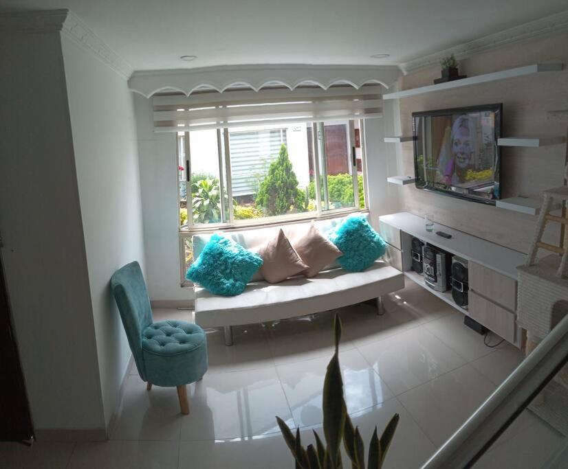 een woonkamer met een bank en een raam bij Confortable Casa Villa Encanto en Bogotá in Bogota