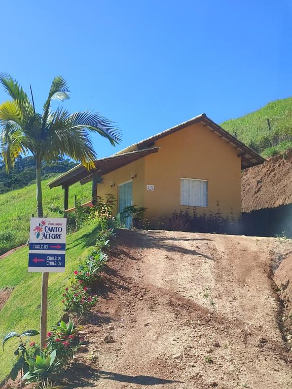 uma casa com um sinal em frente em Pousada Canto Alegre Domingos Martins ES em Domingos Martins