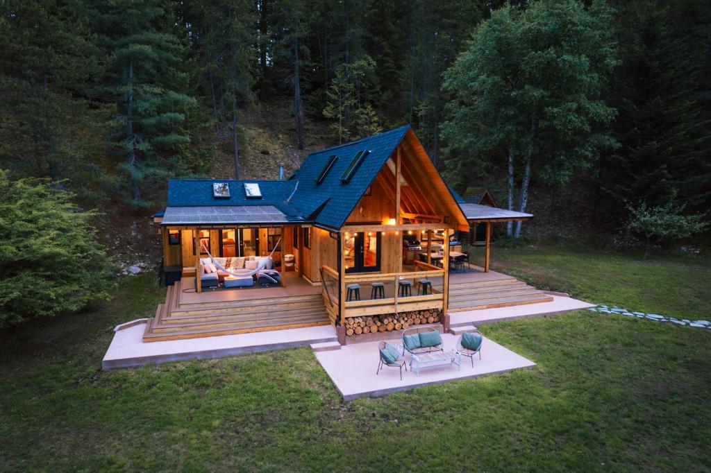 een grote houten hut met een blauw dak bij The Kootenay Lake House - A Private Luxury Retreat in Nakusp