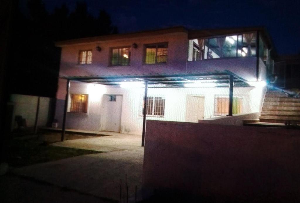 een huis verlicht 's nachts met lichten aan bij Felipe Chalet in La Falda