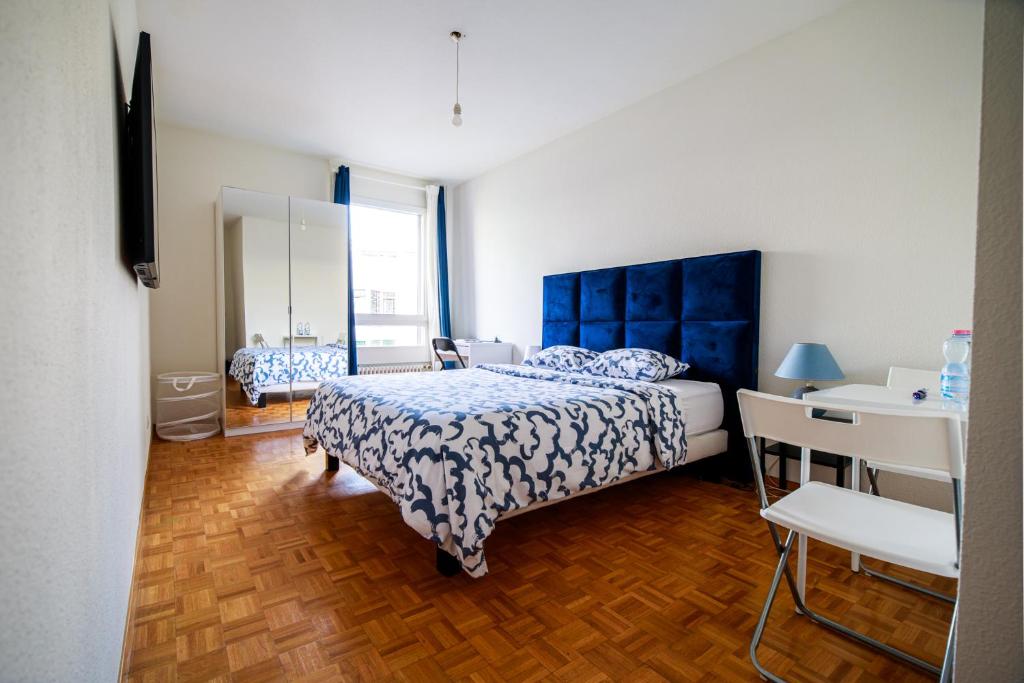 - une chambre avec un lit doté d'une tête de lit bleue dans l'établissement hyper centre carouge QDC, à Genève