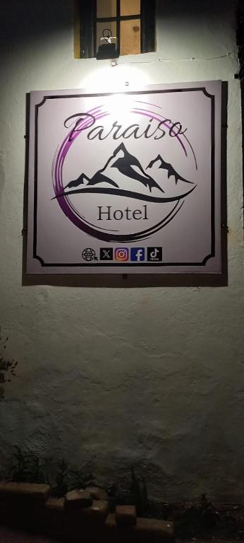 um sinal para um hotel pendurado numa parede em HOTEL PARAISO em La Cumbre