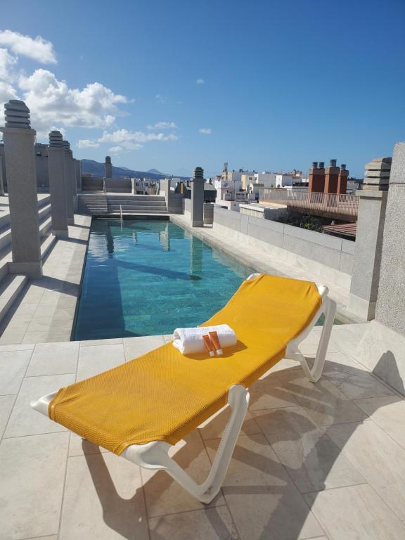 une chaise longue jaune assise au-dessus du toit dans l'établissement Santa Catalina Queen, à Las Palmas de Gran Canaria