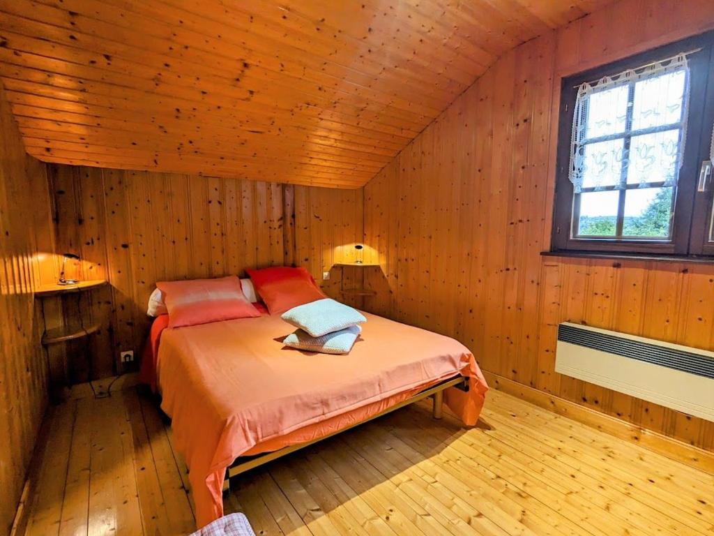 a bedroom with a bed in a wooden room at Gîte Anould, 4 pièces, 6 personnes - FR-1-589-2 in Anould