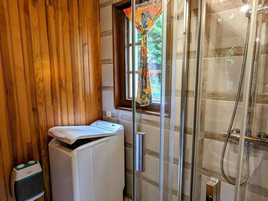 a bathroom with a shower and a washing machine at Gîte Anould, 4 pièces, 6 personnes - FR-1-589-2 in Anould