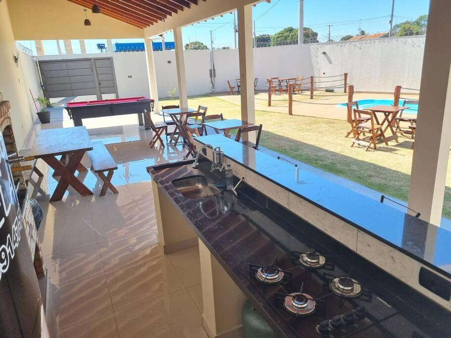 a kitchen with a counter with a stove and picnic tables at Espaço gelada in Campo Grande