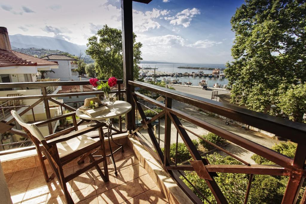 balcón con mesa, sillas y vistas al agua en Hotel Morfeas en Platamonas