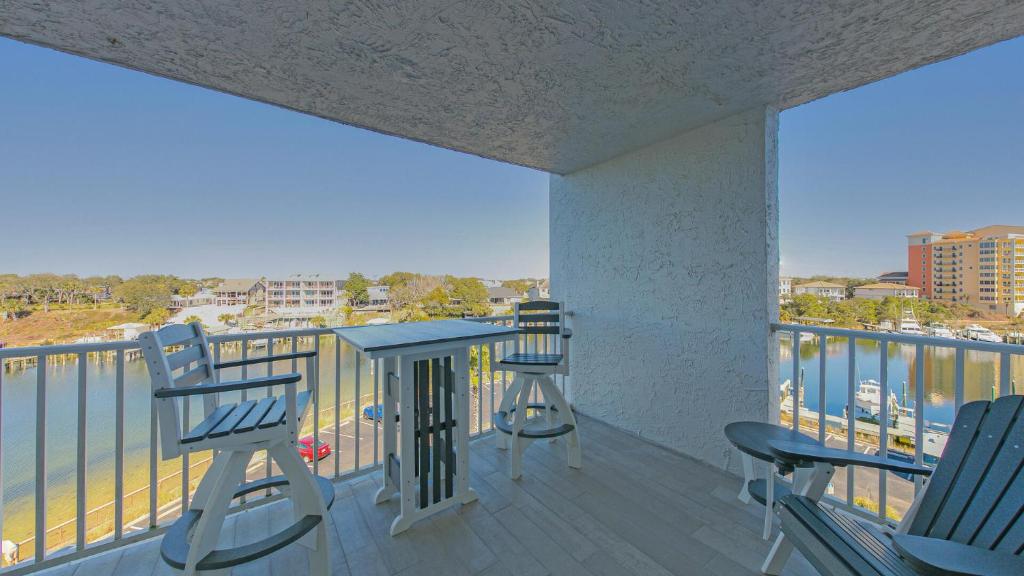 - un balcon avec 2 chaises, une table et 2 fenêtres dans l'établissement Dolphin Point 601B - Remodeled 2BR with Destin Harbor Views, à Destin
