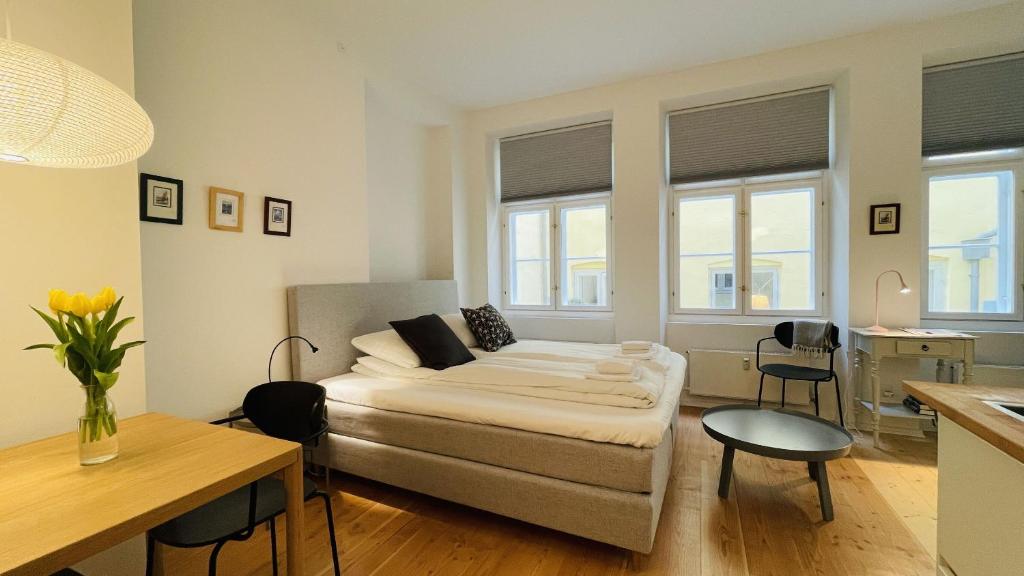 a bedroom with a bed and a table and some windows at ApartmentInCopenhagen Apartment 1539 in Copenhagen