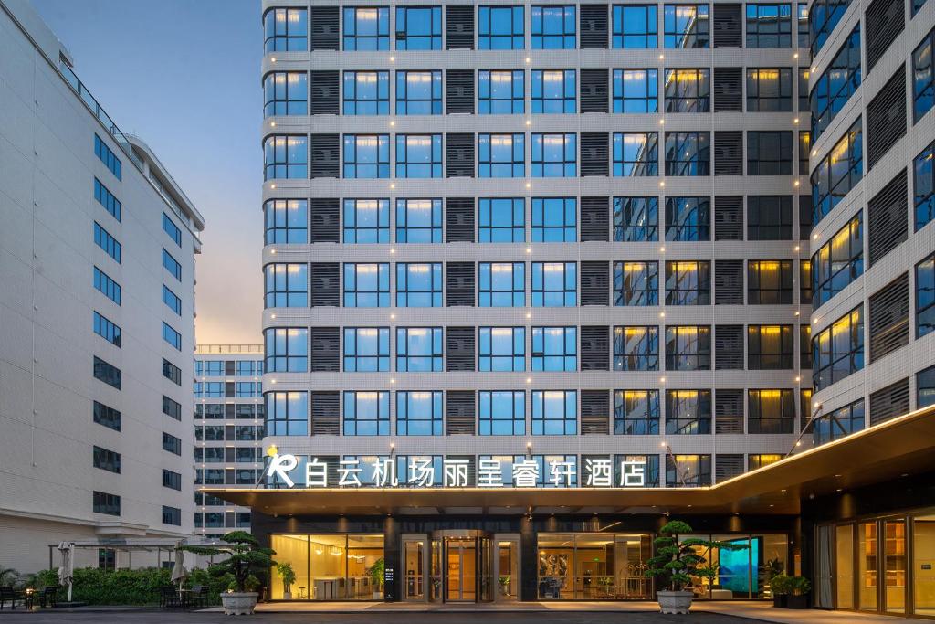 een groot kantoorgebouw met veel ramen bij Guangzhou Baiyun Airport Rezen Select Hotel in Huadu