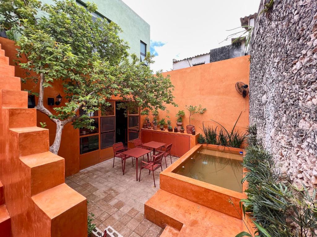 a courtyard with a pool and a table and chairs at Kuka y Letras in Mérida