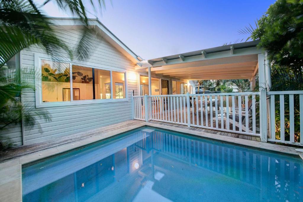 a swimming pool in front of a house at A Perfect Stay - A Summer Cottage in Byron Bay