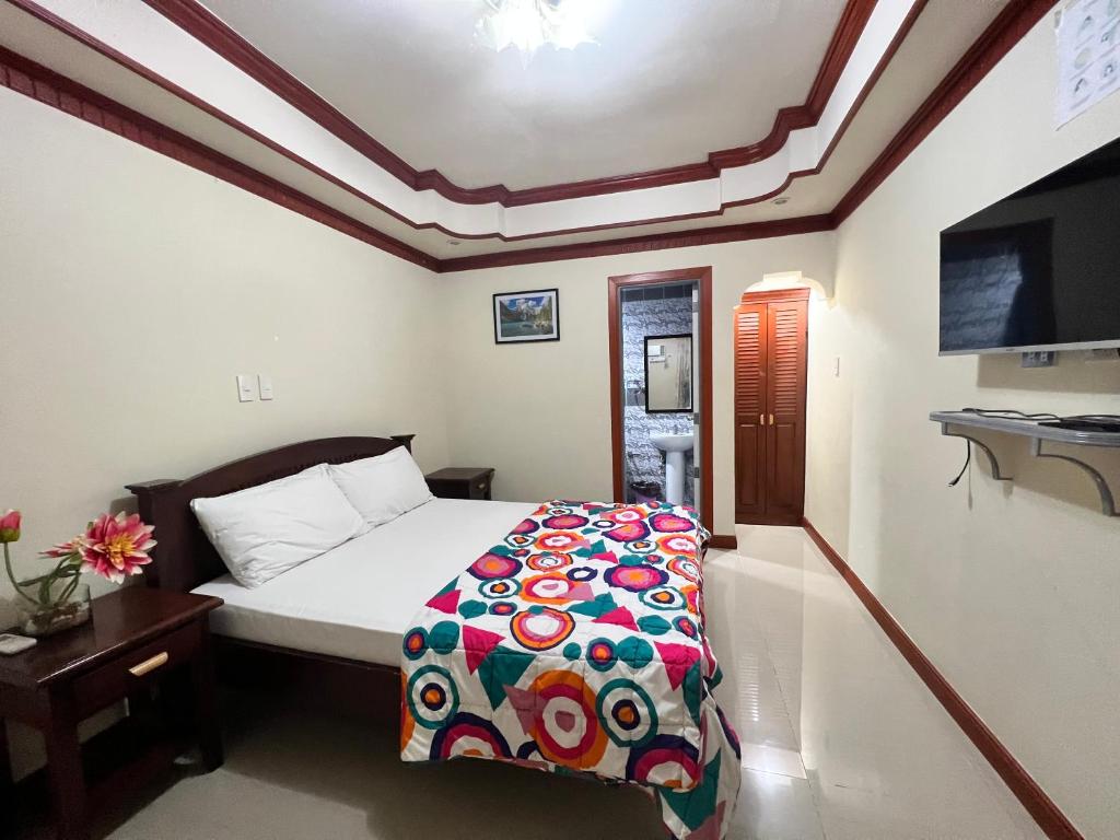 a hotel room with a bed and a tv at Siargao By Grace Suites in General Luna