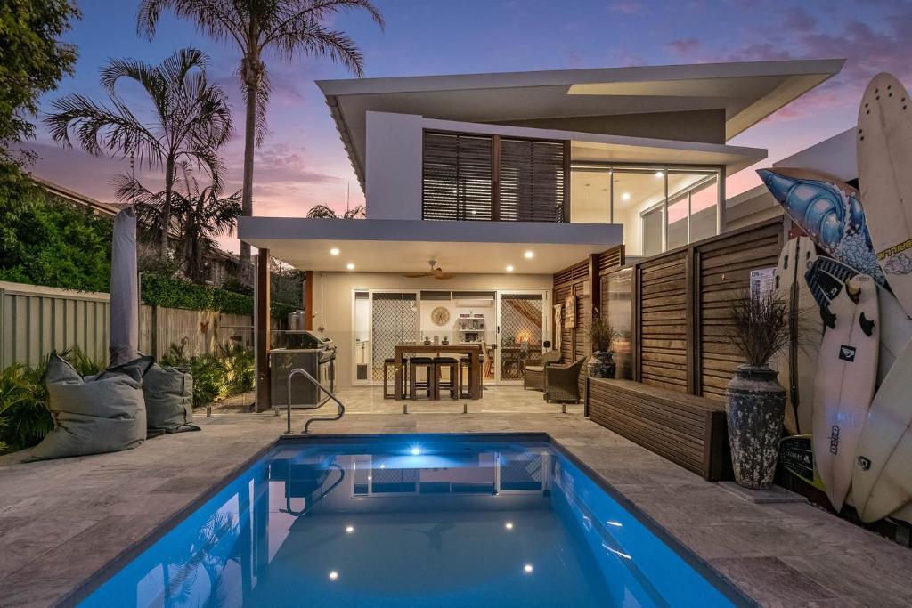 a house with a swimming pool in front of a house at A Perfect Stay - Byron Sunrise in Byron Bay