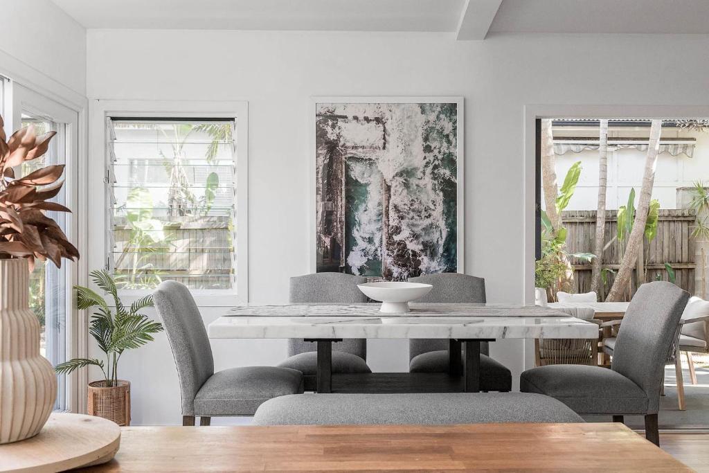 a dining room with a white table and chairs at Cape Cottage - 5 bed charming cottage close to everything in Byron Bay