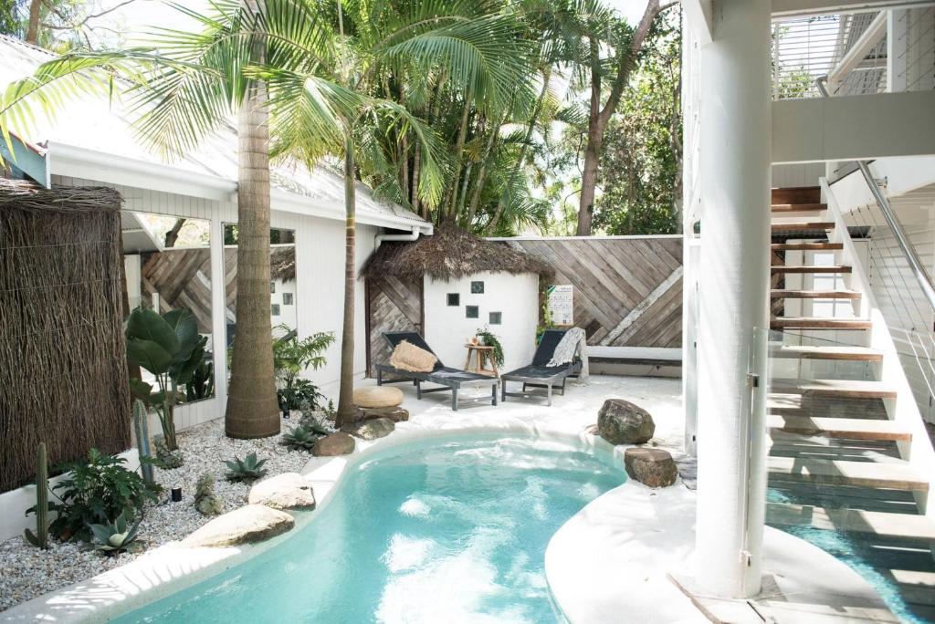 a swimming pool in a backyard with a palm tree at A Perfect Stay - Cactus Rose Villa in Byron Bay