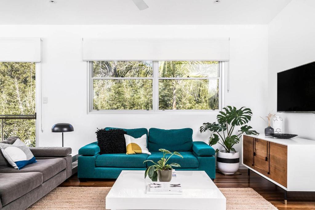 a living room with a blue couch and a tv at A Perfect Stay - Clique 3 in Byron Bay