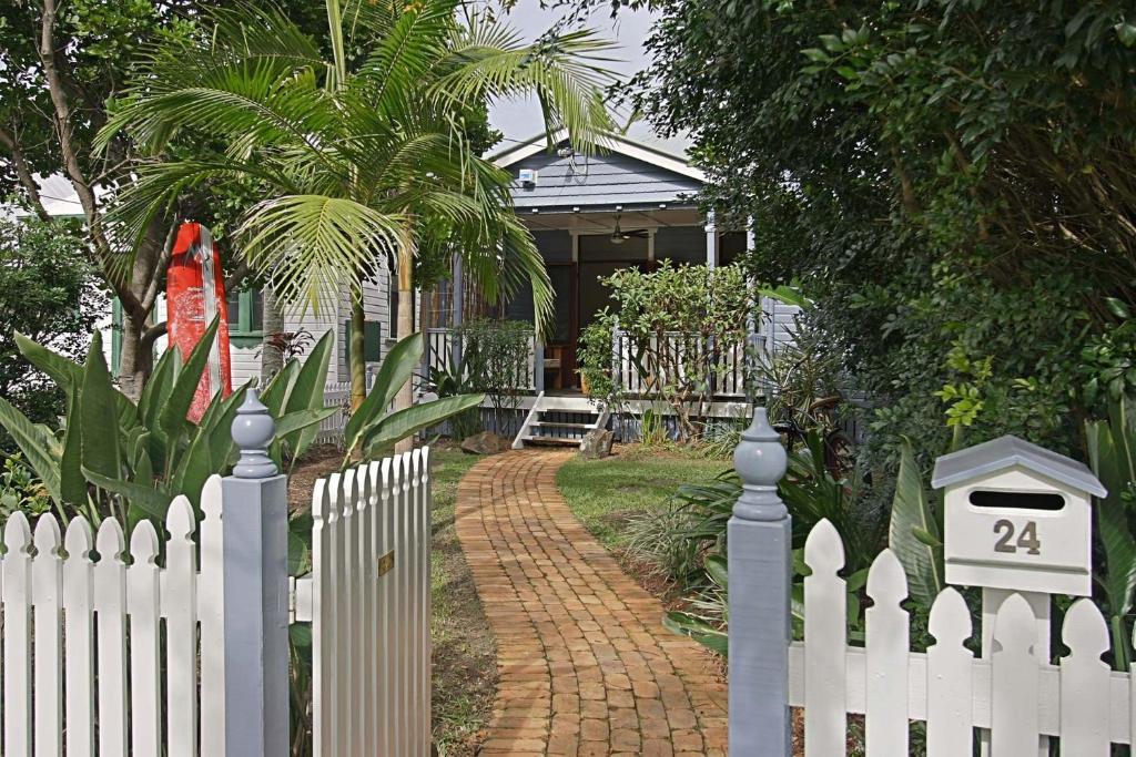 a white picket fence in front of a house at A Perfect Stay - Harkaway in Byron Bay