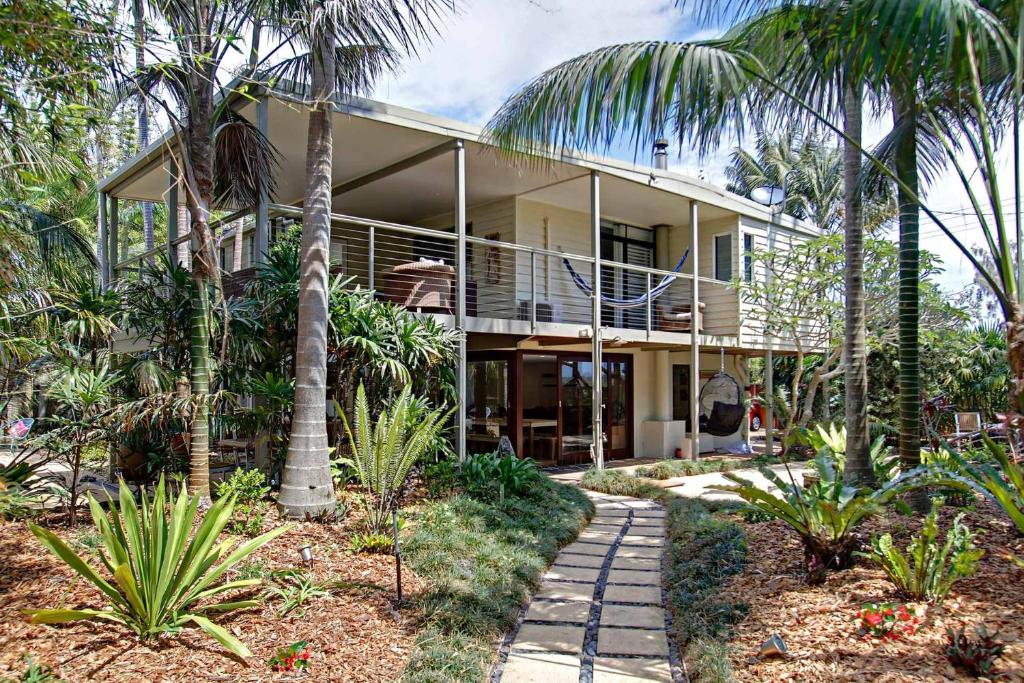 a house with palm trees in front of it at A Perfect Stay - Jimmys Beach House in Byron Bay