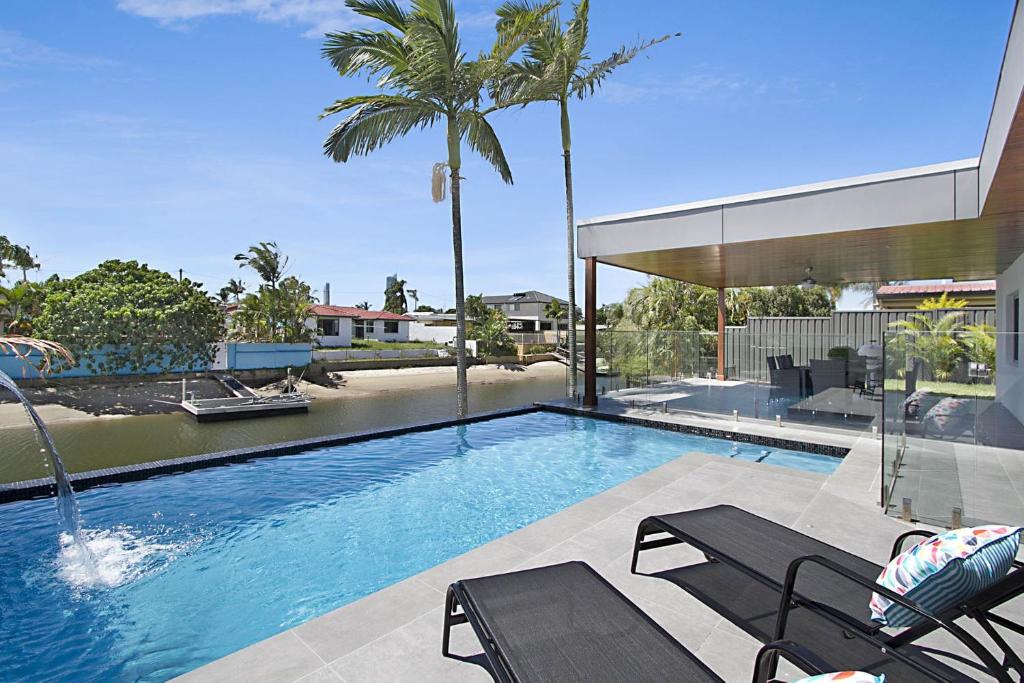 basen z 2 krzesłami i palmą w obiekcie A Perfect Stay - Buena Vista w mieście Gold Coast
