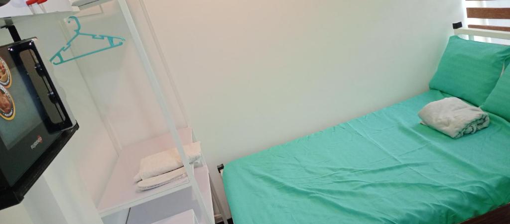 um quarto com uma cama verde e uma prateleira em KS RESIDENCES em Manila