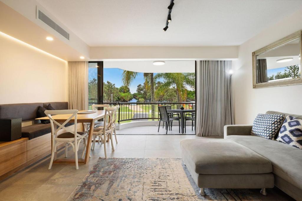 a living room with a couch and a table and chairs at A Perfect Stay - Pacific Blue in Byron Bay