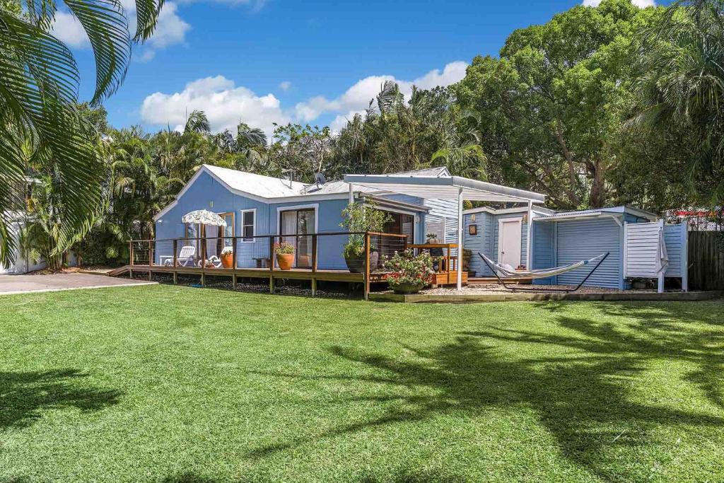 a blue house with a lawn in front of it at A Perfect Stay - San Juan Surfers Cottage in Byron Bay