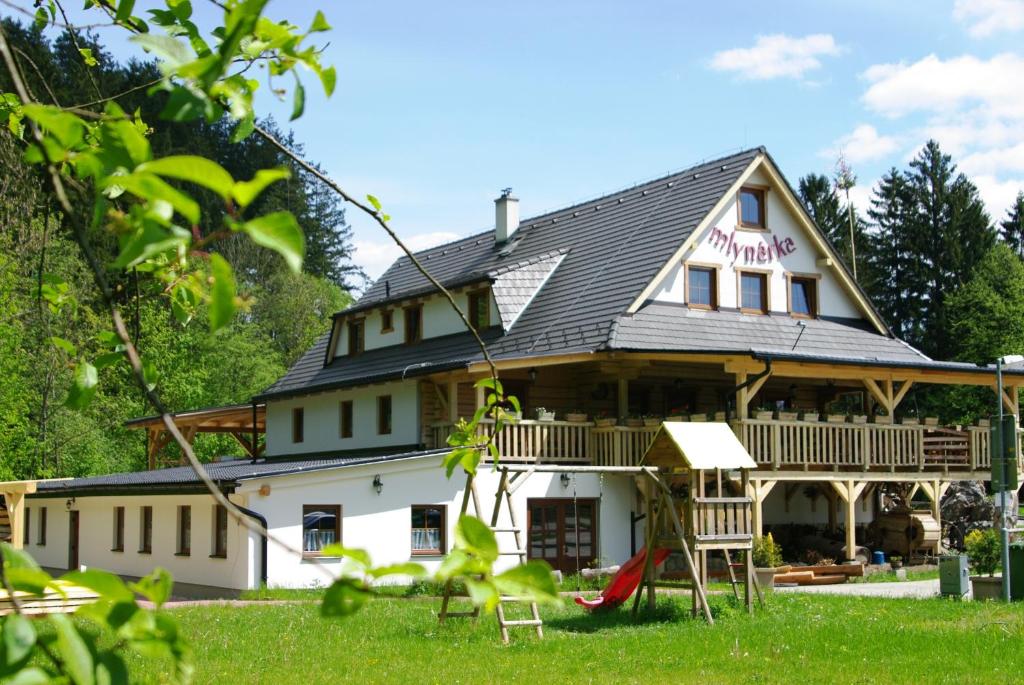 una gran casa blanca con techo de gambrel en Penzión Mlynárka en Rajecké Teplice