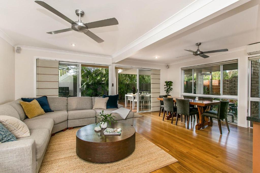 una sala de estar con un sofá y una mesa en Tradewinds 4 - beachside 3 BR townhouse, en Bangalow