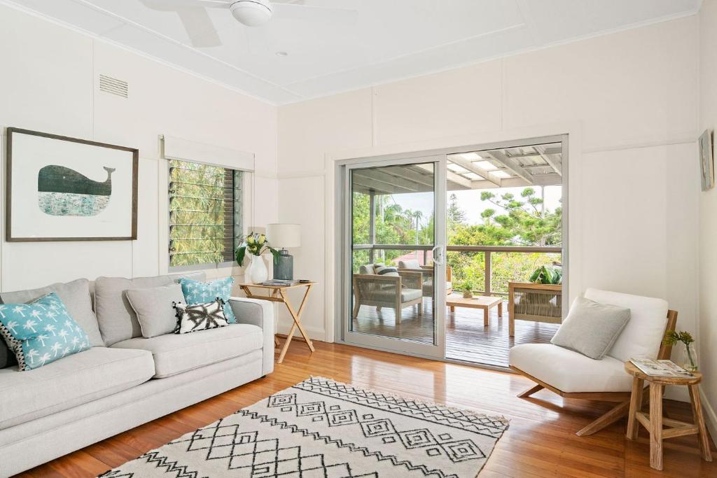 a white living room with a white couch and chairs at A Perfect Stay - The White Rabbit in Byron Bay