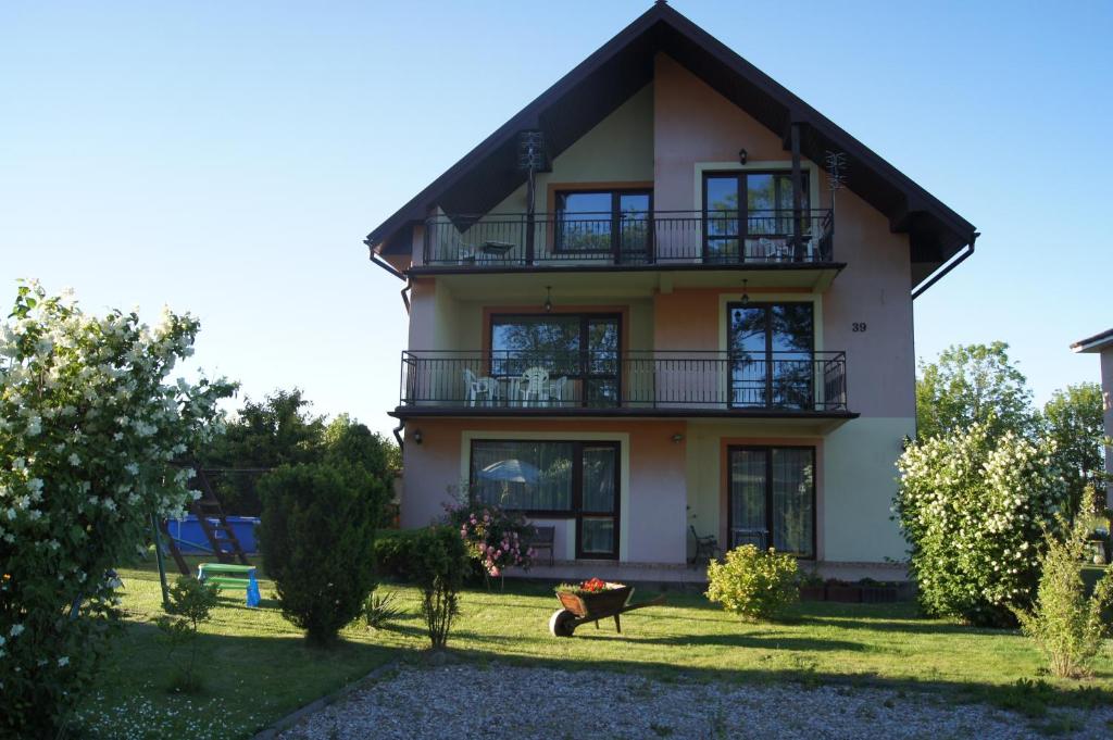 a house with a balcony and a yard at Szyper pokoje i domki in Władysławowo