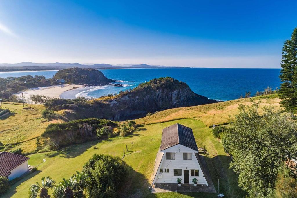 een wit huis op een heuvel naast de oceaan bij A Perfect Stay - A Frame in Scotts Head