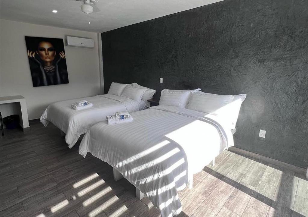 sypialnia z 2 łóżkami z białą pościelą w obiekcie LONGVIEW HOME-STUDIOS w mieście Tepic