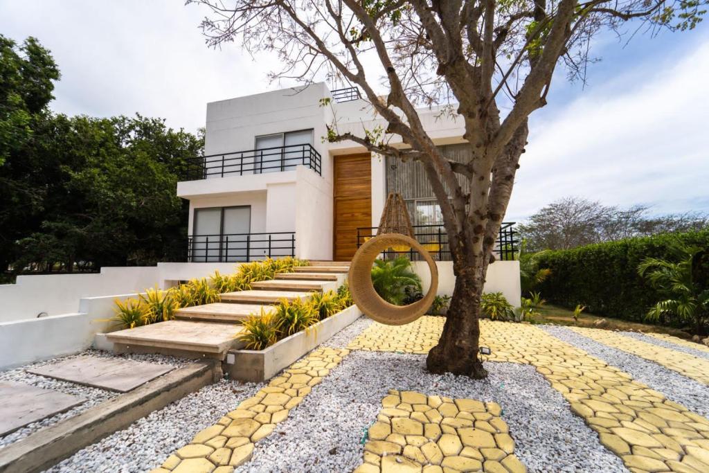 ein Haus mit einem Baum im Vorgarten in der Unterkunft Casa privada en Isla Barú 5BR in Barú