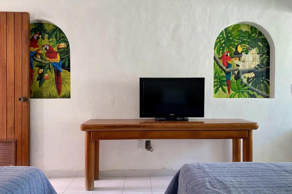 TV en una mesa de madera en una habitación en Condominiums in Solymar, en Cancún