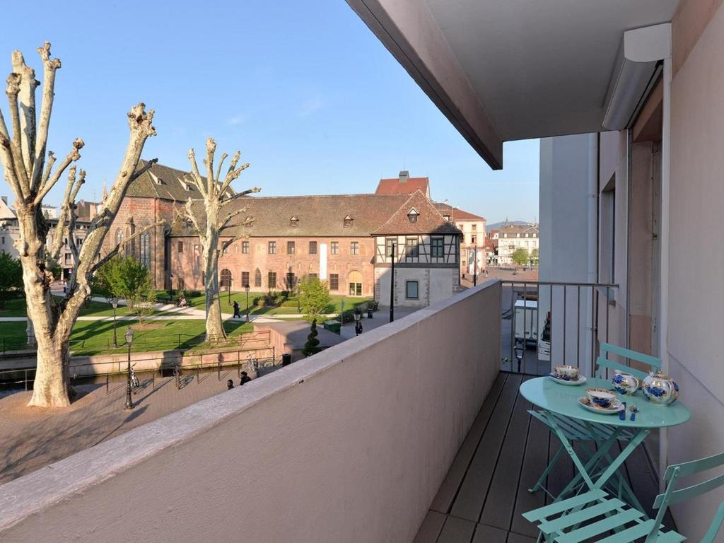 a balcony with a table and a view of a building at Appartement de luxe en hyper-centre avec 3 chambres, balcon, parking, proche Musée Unterlinden - FR-1-744-37 in Colmar