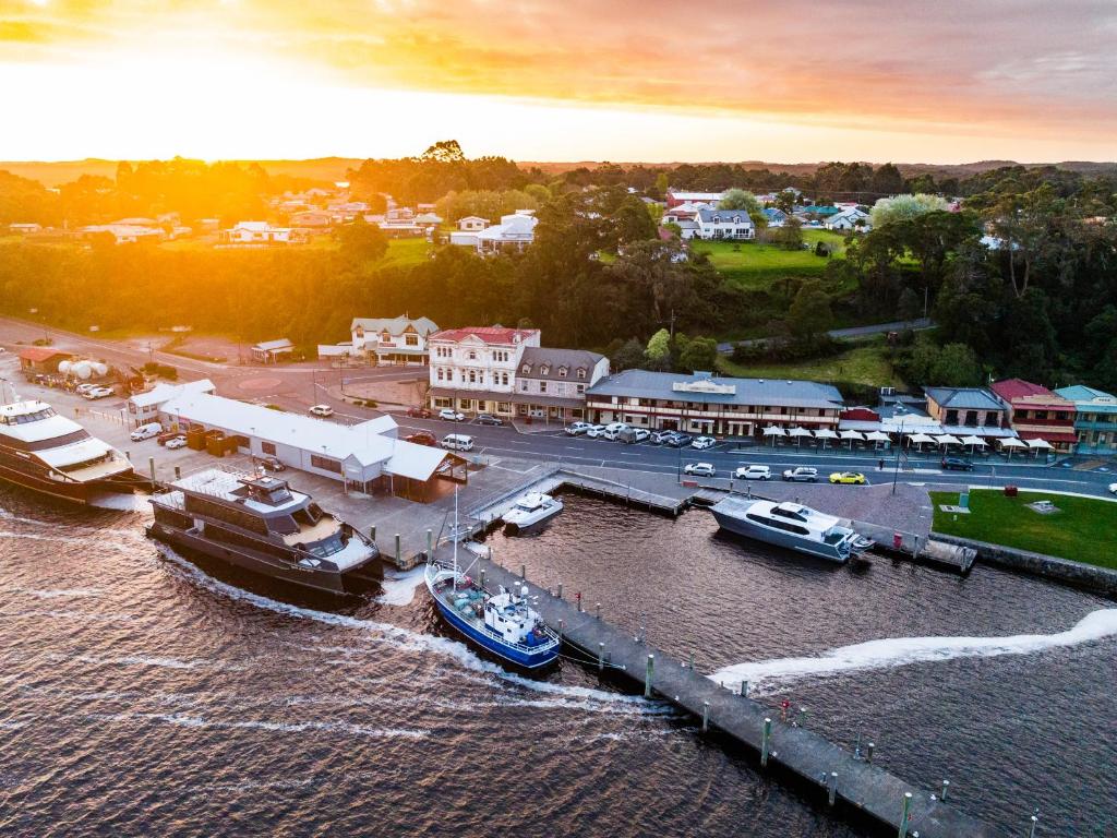 a group of boats docked at a dock in the water at Strahan Village in Strahan