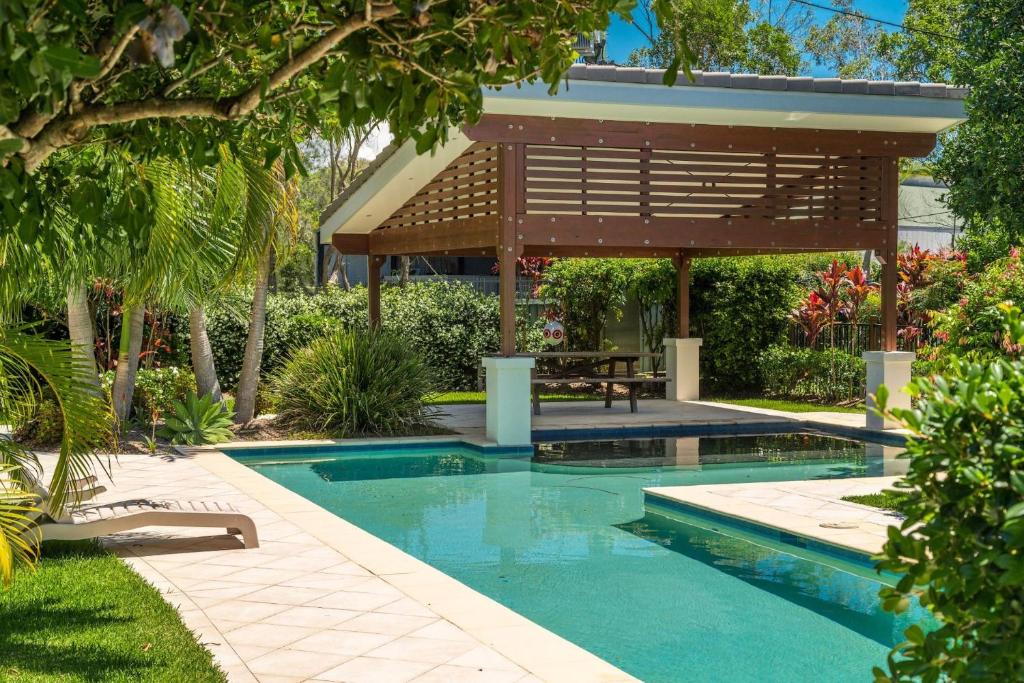 a swimming pool in a yard with a pergola at A Perfect Stay - Ocean Walk in Byron Bay