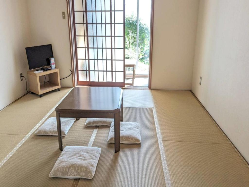 sala de estar con mesa y TV en Amanohashidate Youth Hostel - Vacation STAY 94805v, en Miyazu