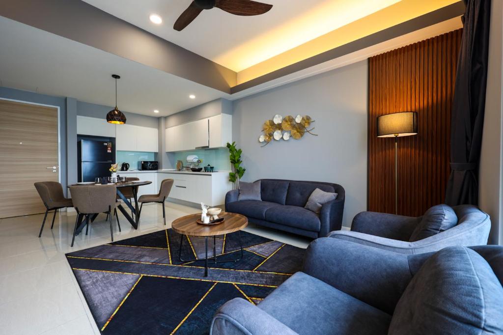 a living room with blue couches and a table at Sentral Suites Kl Sentral By Luxe Home in Kuala Lumpur