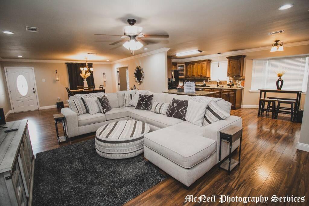 a living room with a white couch and a kitchen at “Home Away From Home” ( HAFH) in Baton Rouge