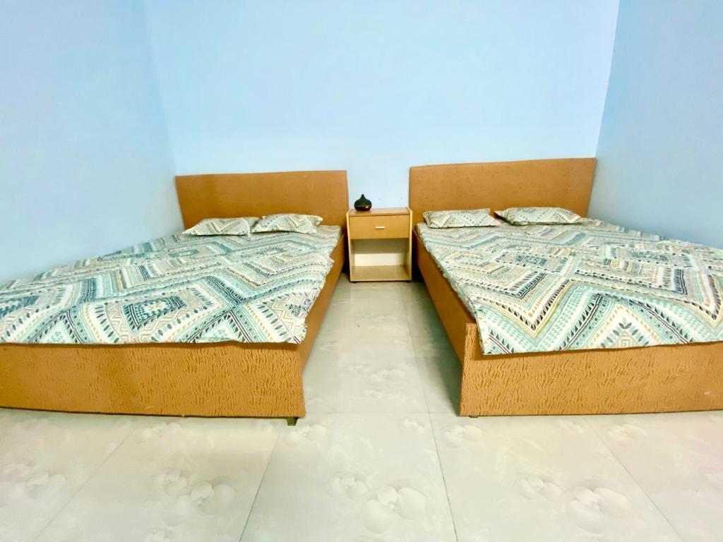 2 Betten nebeneinander in einem Zimmer in der Unterkunft Nhà nghỉ Đoàn Gia in Dồng Xoài