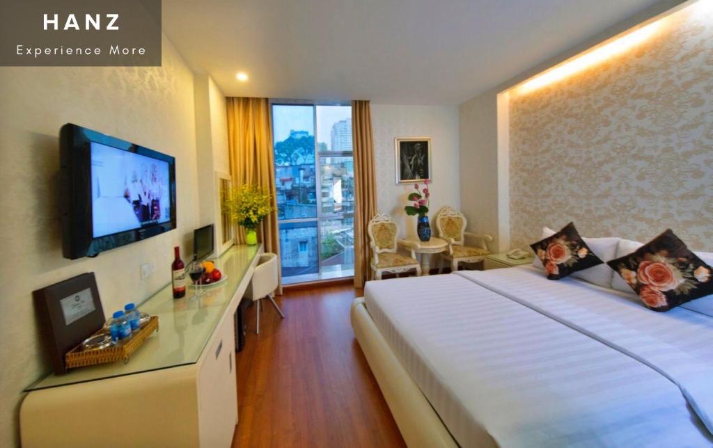 Pokój hotelowy z dużym łóżkiem i telewizorem w obiekcie HANZ The Golden Star Hotel w Ho Chi Minh